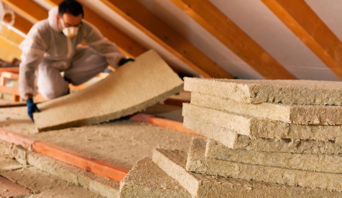 Professional worker replacing wet insulation of roof